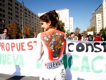 Estudiantes universitarios protestan frente a la moneda con sus cuerpos pintados