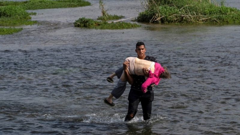 La historia detrás de la dramática imagen de una adulta mayor venezolana que cruzó en brazos de un joven un río desde México a EE.UU.