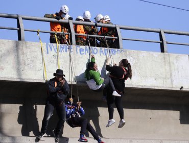 Pobladores se cuelgan de pasarela en Peñalolén para exigir soluciones habitacionales