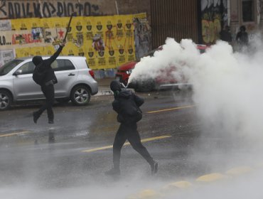 Desórdenes registrados en la Alameda dejan a tres detenidos: encapuchados quemaron una bandera de Chile