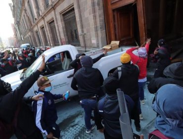 Estudiantes de Ayotzinapa derriban puerta del Palacio Nacional de México en plena conferencia de López Obrador